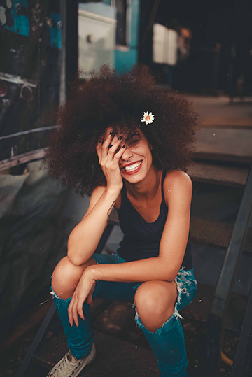 Woman with flower in hair sitting and smiling