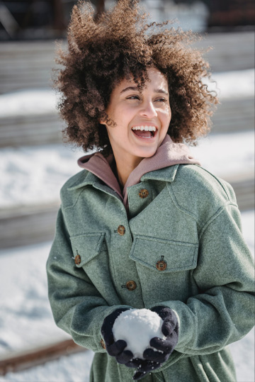 Woman smiling while holding snowball